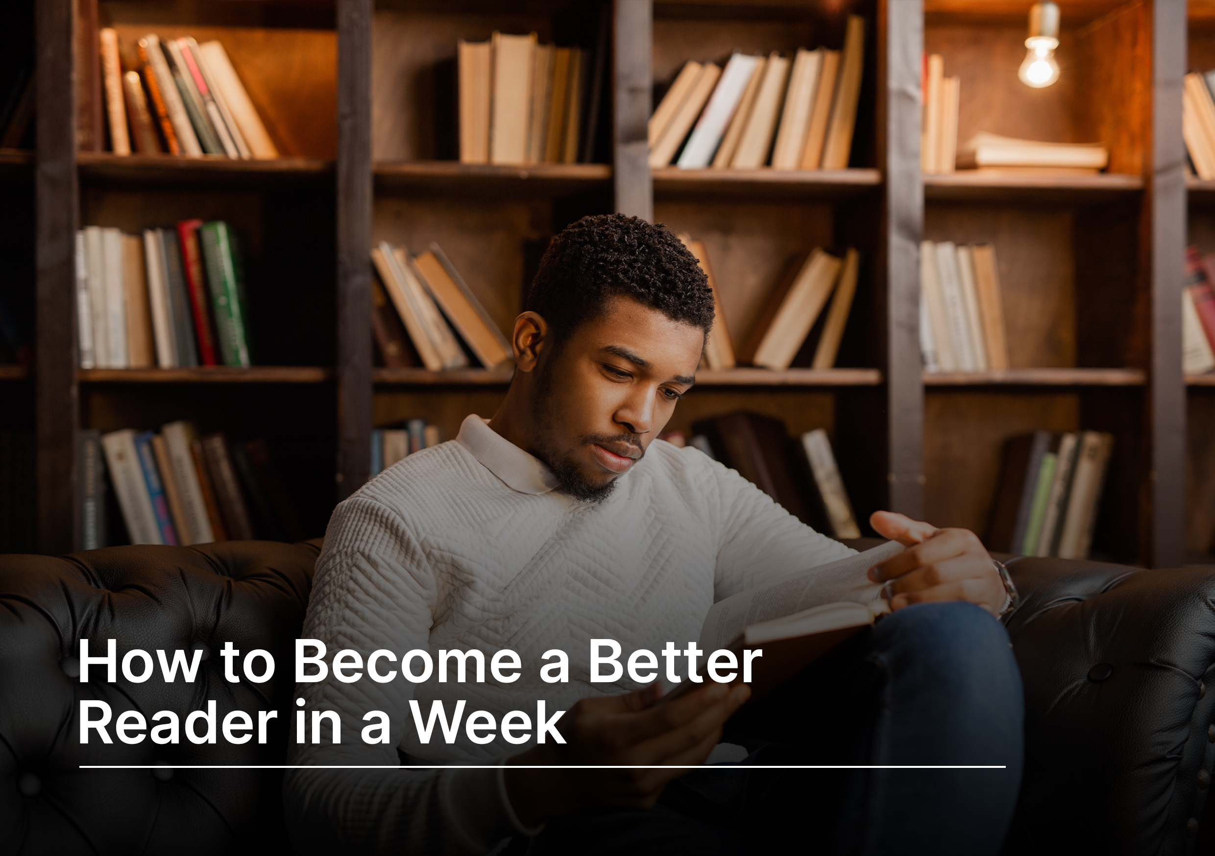 A man sitting down and reading a book in front of a book shelf